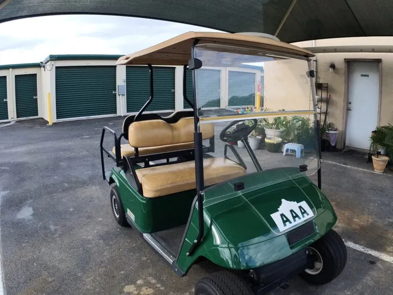 Golf cart outdoor by row of storage units. 